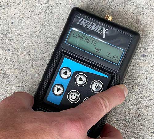 Concrete moisture test being performed with an electronic device
